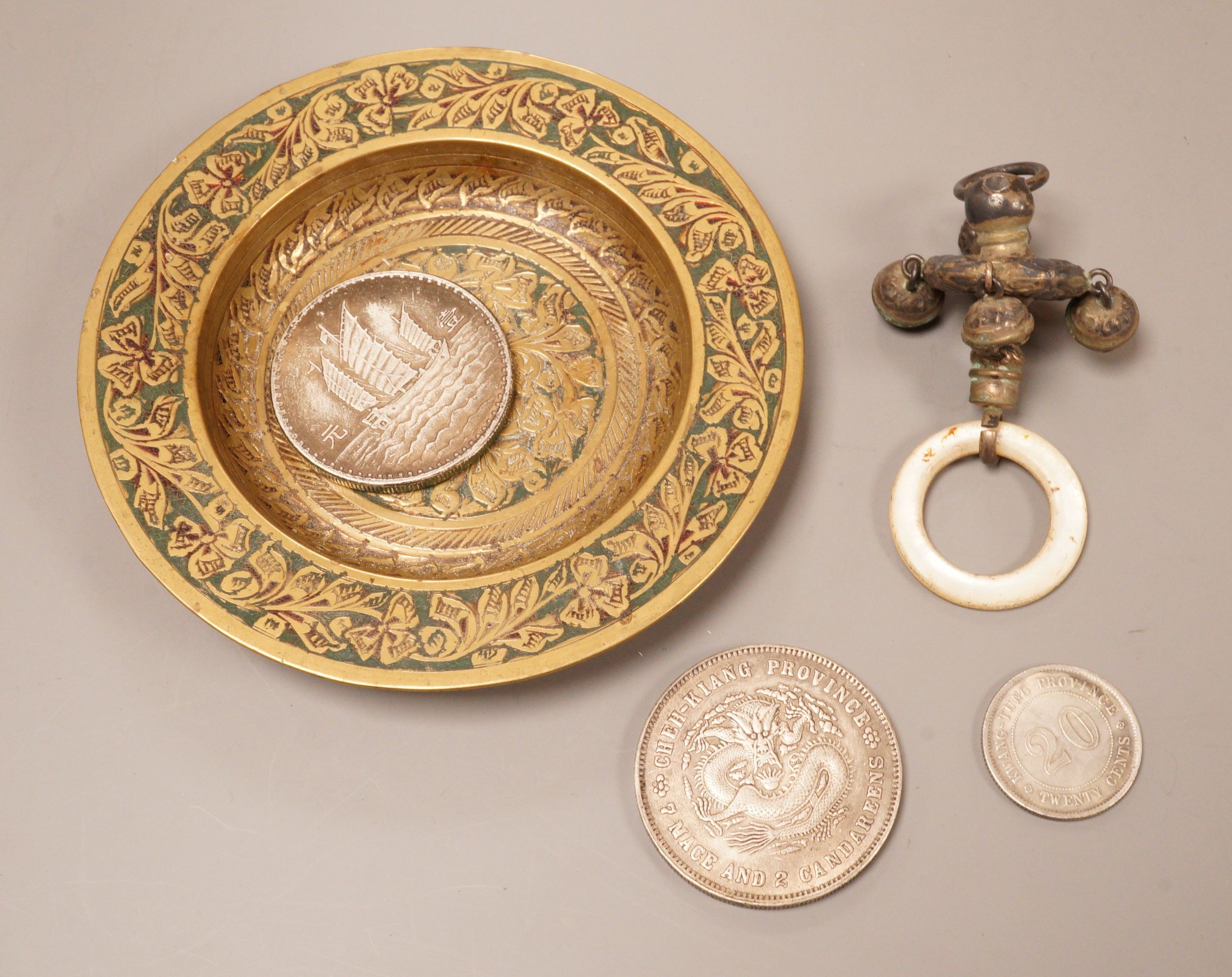 A brass tray, various coins and a rattle dish, 11.5cm diameter